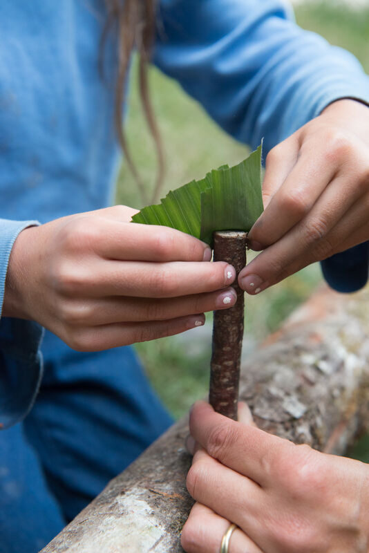 mains des enfants bricolent avec des feuilles et des bâtons